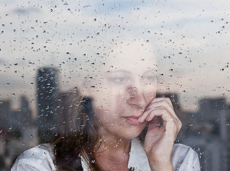 A person gazing through a window in contemplation